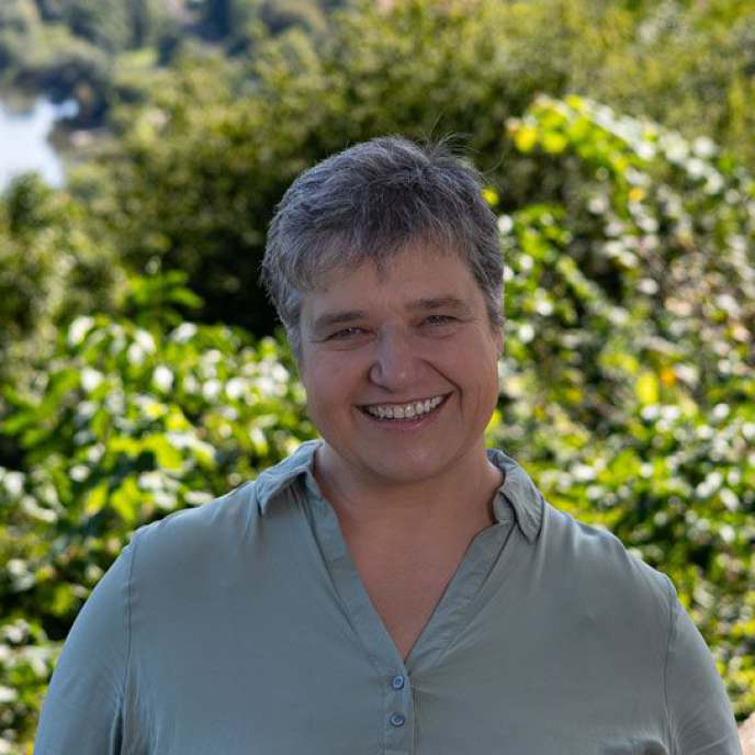 Frau, grünes Oberteil, draußen, fröhliches Gesicht