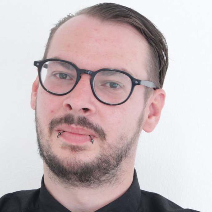junger Mann, dunkle Haare, Brille, Bart, freundliches lächeln