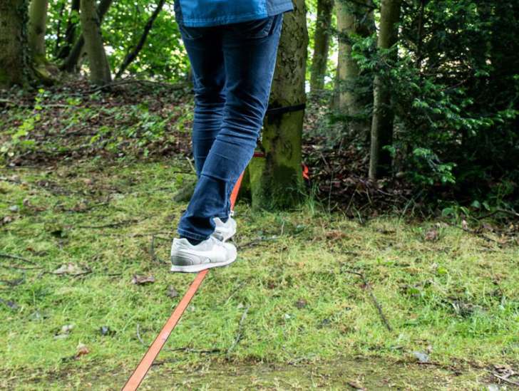  Eine Person balanciert im Wald 