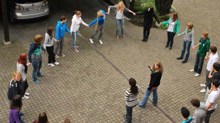 Eine große Gruppe Jugendlicher steht im Kreis 