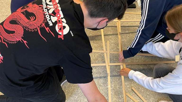 Jugendliche arbeiten mit Holzstäben
